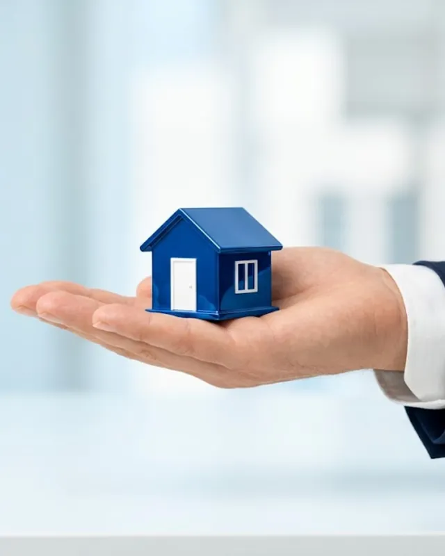 Open hand holding a small blue model house