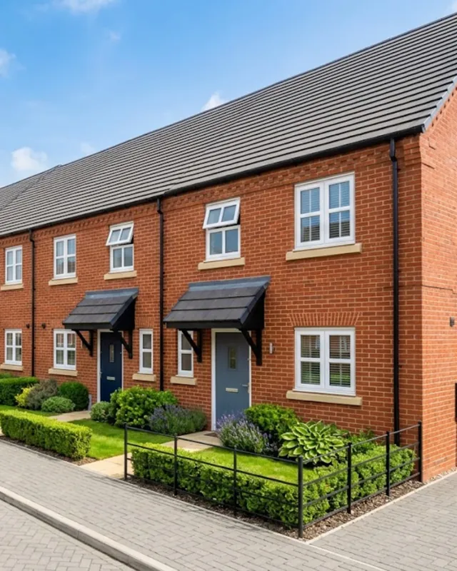 Row of modern red-brick terraced houses with small front gardens